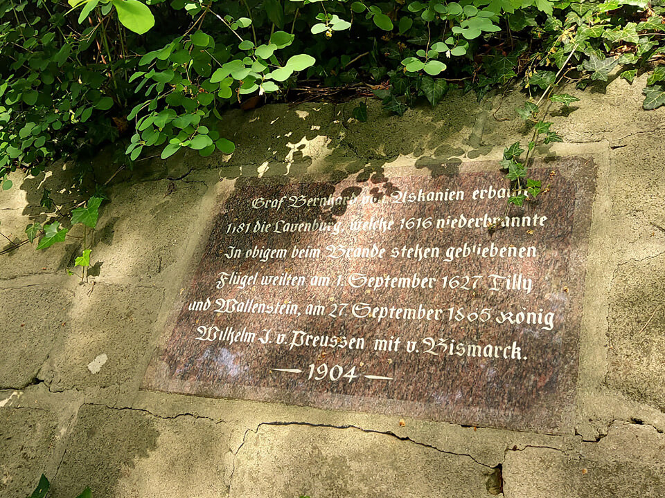 Inschrift am Wegesrand zur Geschichte der Burg. Blick auf die Geschichte der Burg.